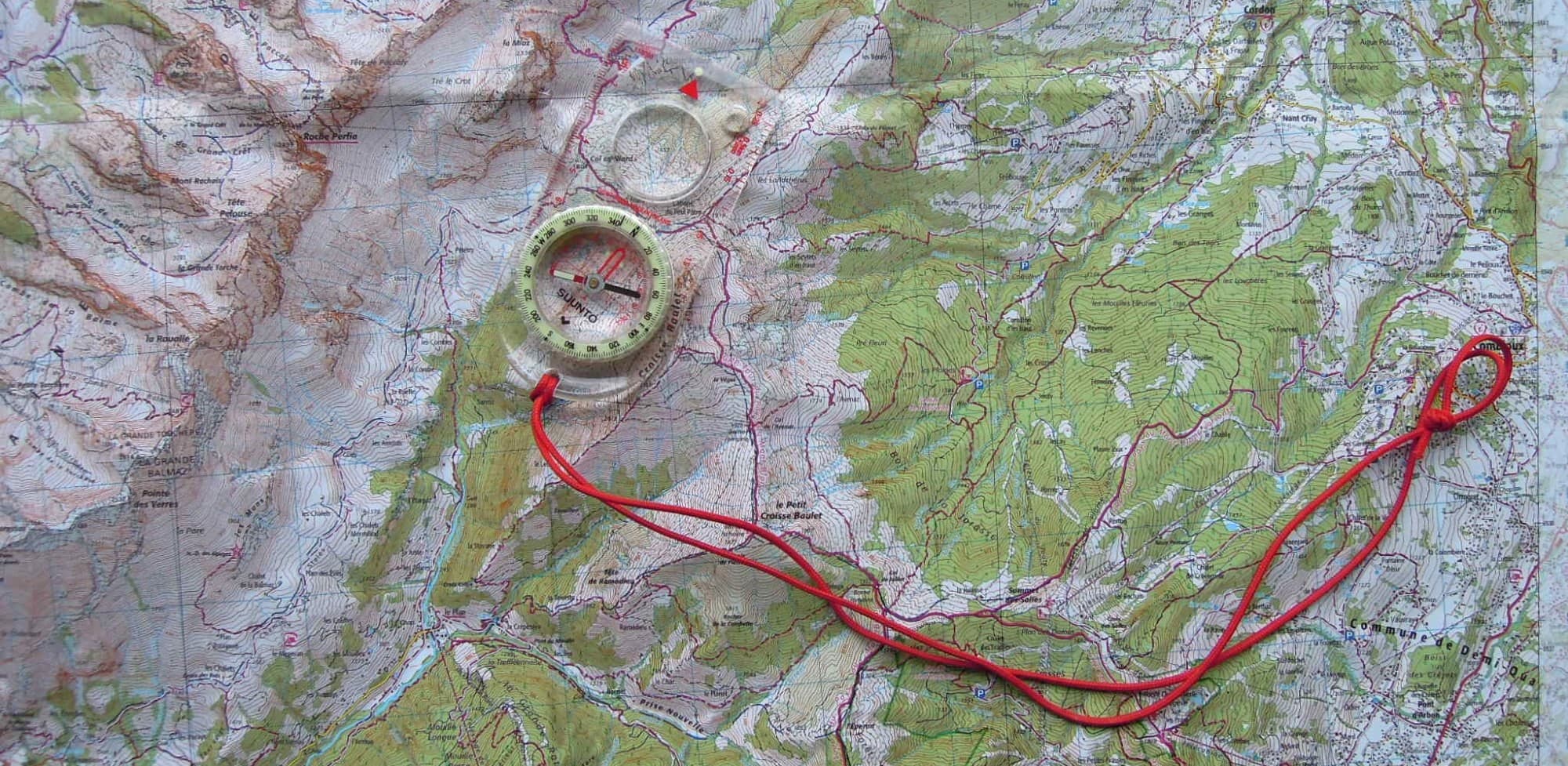 Carte IGN de Haute-Savoie posée à plat avec une boussole Suunto, pour un atelier d'orientation en montagne.